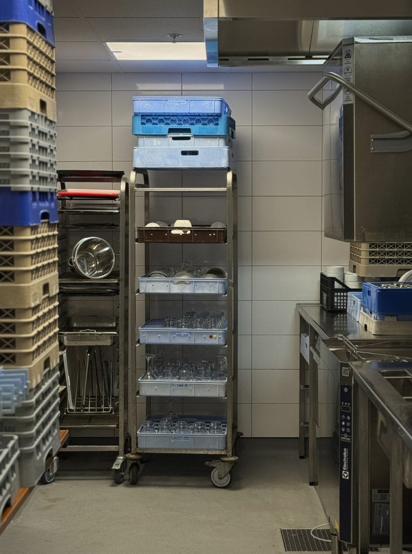 Oppvaskrom med oppvaskkurver underbenk oppvaskmaskin og hetteoppvask og rustfrie hyller