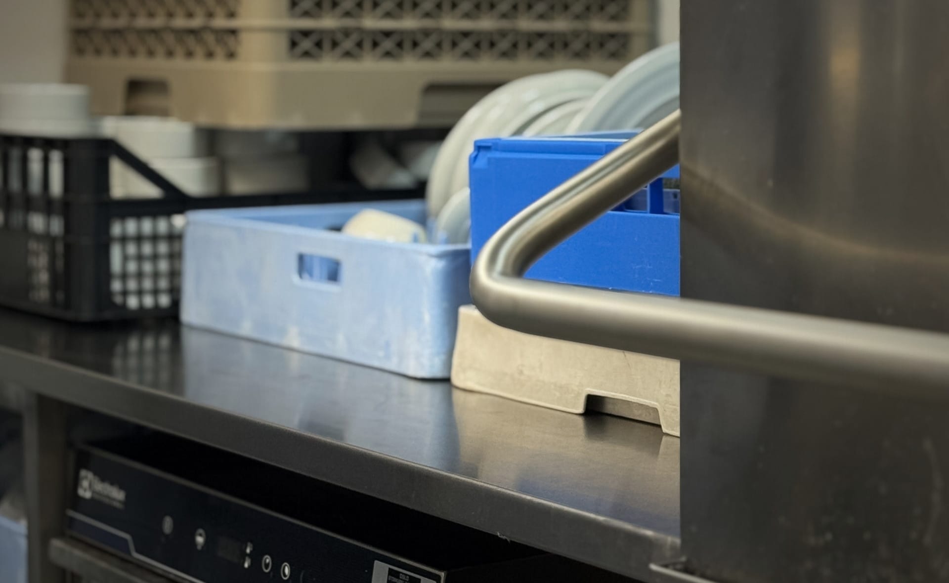 Hetteoppvaskmaskin og underbenk oppvaskmaskin fra electrolux og rustfritt bord med oppvaskkurver ved grenseløs restaurant