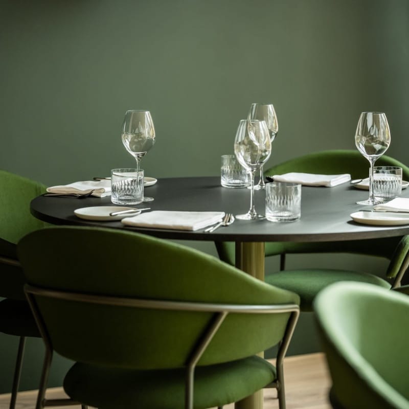 bord med bordglass og servise og stoler ved siden av på restaurant