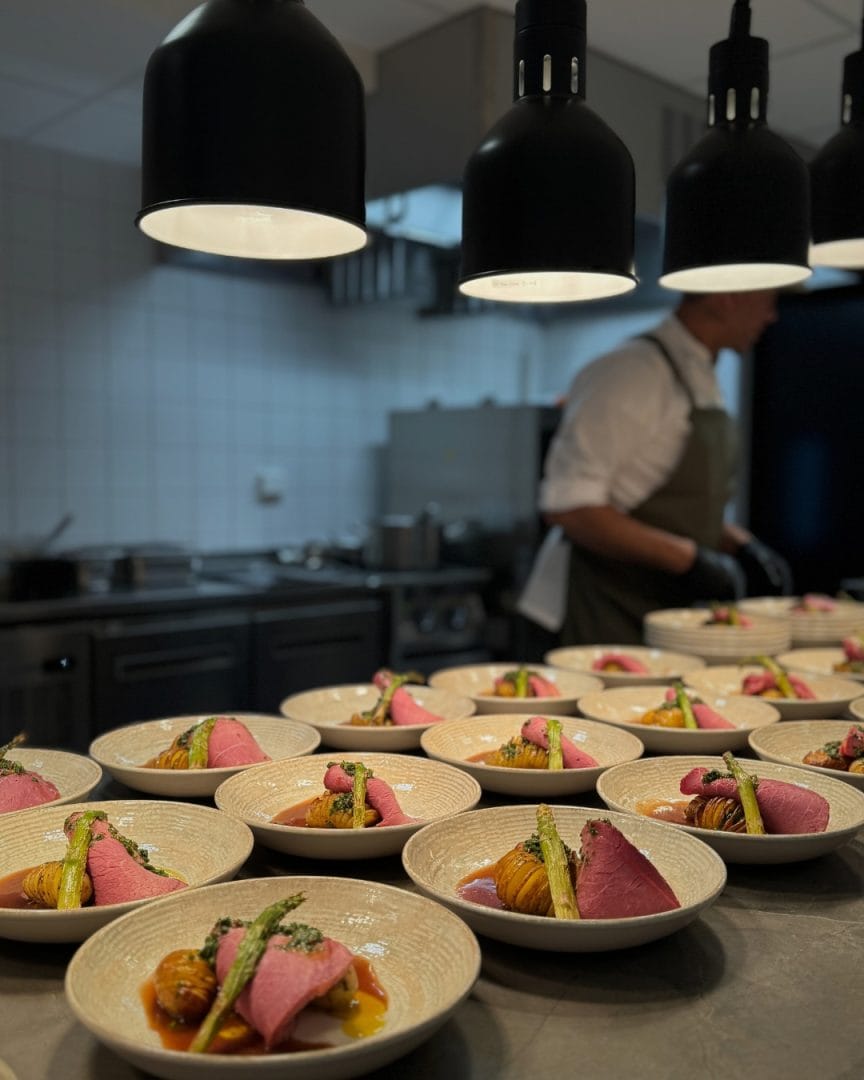 varmelamper ved kantine over matretter med kokk i bakgrunnen