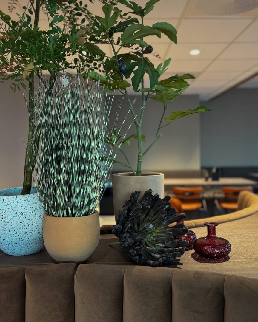 modulsofa med kunstige planter og dekor plassert bak rygg i kantine og restaurant