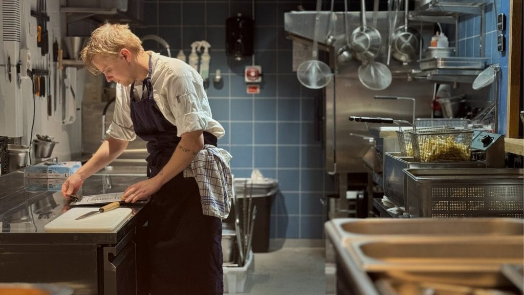 mann på storkjøkken som klargjør mat