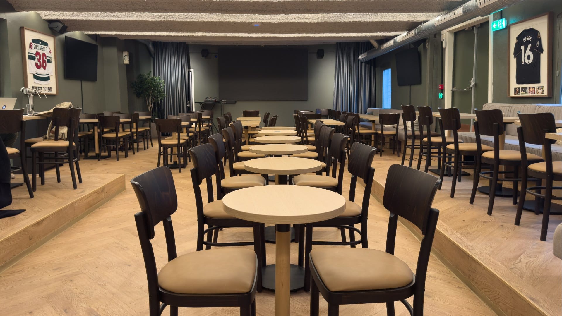 oversikt over fotballpub ved nieu scene med stoler bord og sofa og tv i bakgrunn
