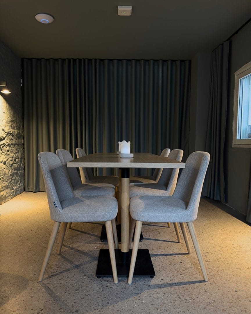 chambre separe stoler med grått tekstil og gardin i bakgrunn