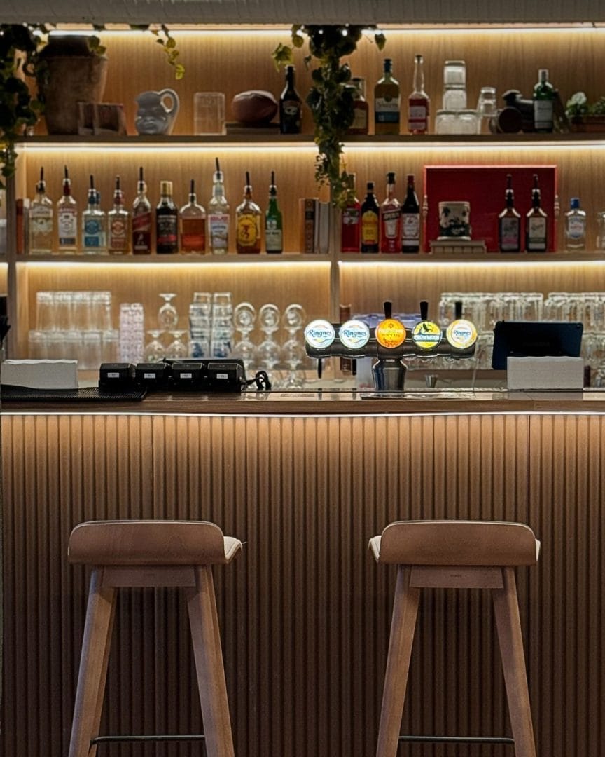 to barstoler ved skreddersydd bar og hyllesystem i bakgrunn