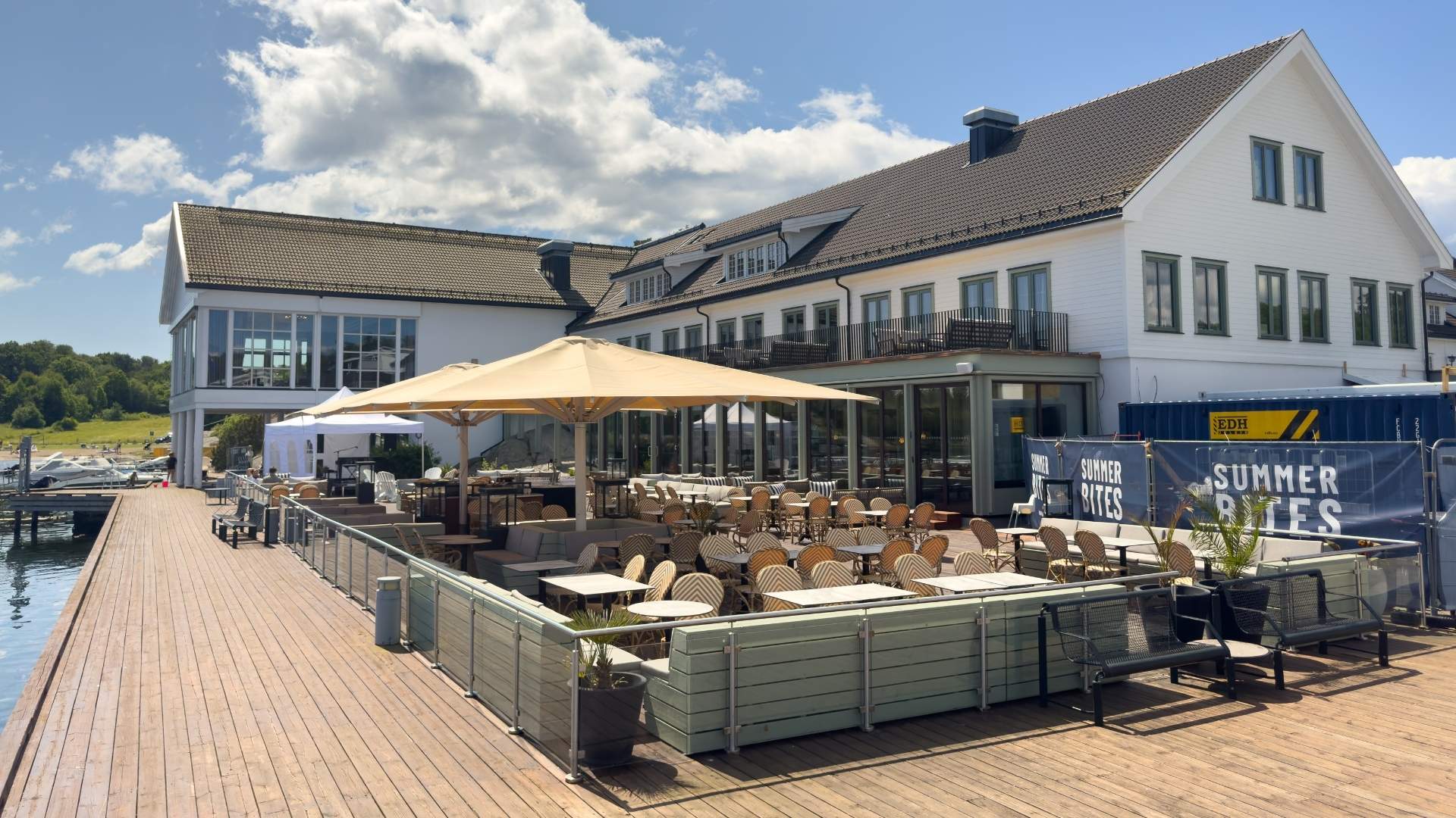 uteservering med utemøbler og parasoller på utsiden av havna hotell tjøme