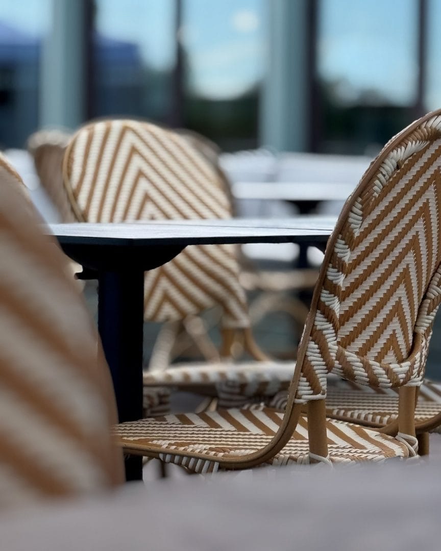 rottingstol med bord utendørs på uteservering ved havna hotell
