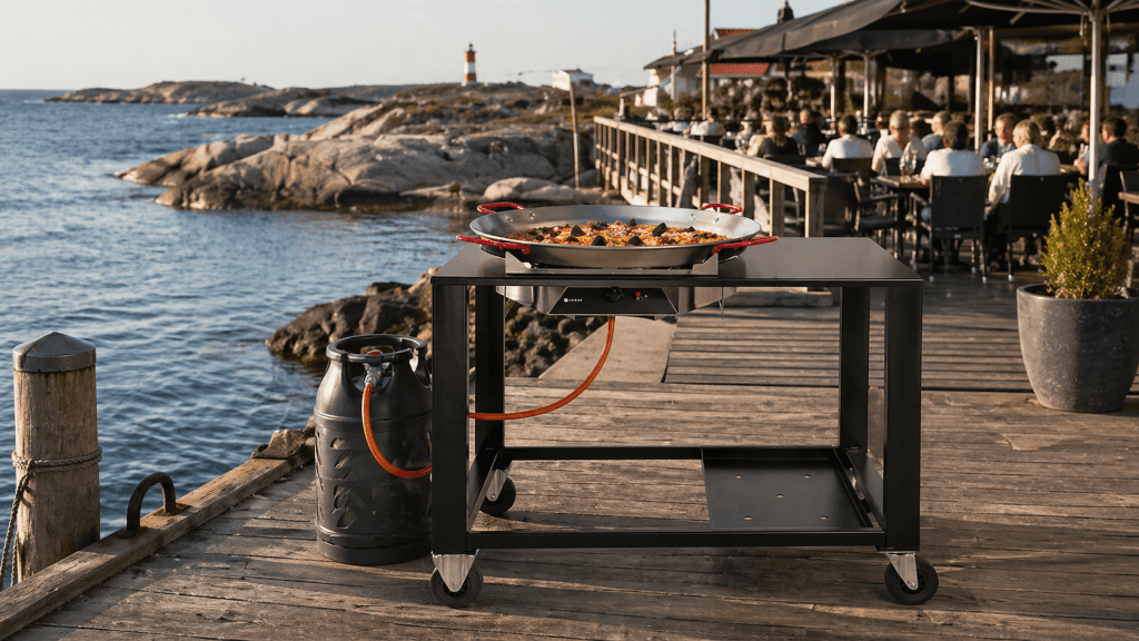 Paellagrill ved bryggerestaurant nær sjøen i solskinn