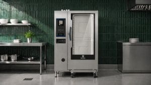 kombidamper på storkjøkken med grønn flislagt vegg og rustfri benk