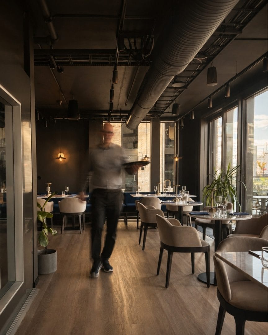 Moderne restaurant med servitør i bevegelse