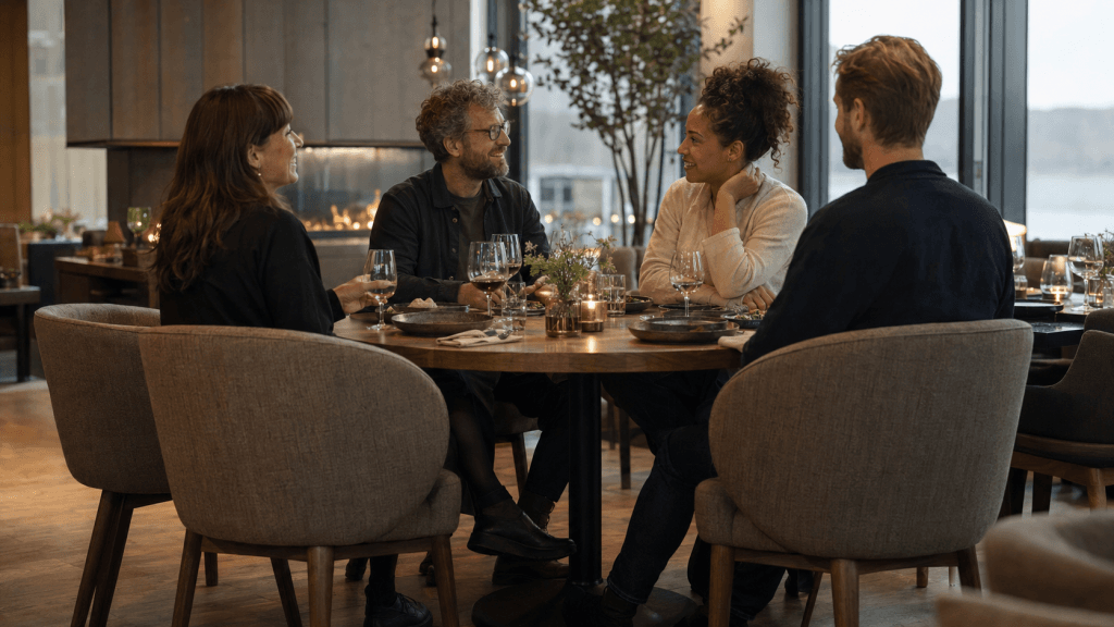 Fire personer samles rundt bordet på restaurantstoler