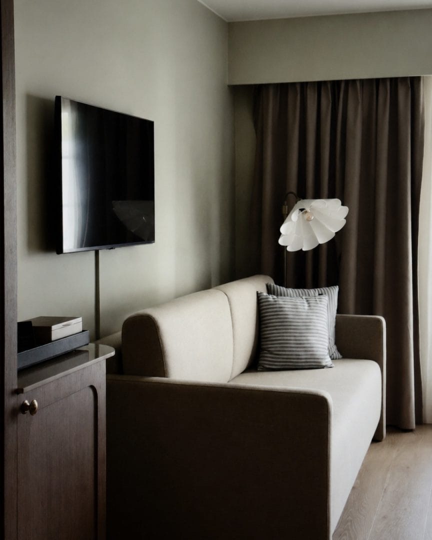 sofa på hotellrom med tv på veggen
