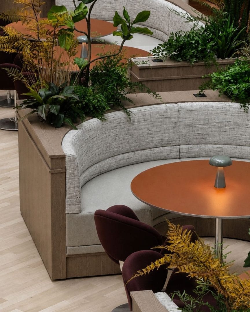 buet hjørnesofa med planter og restaurantbord i kantine