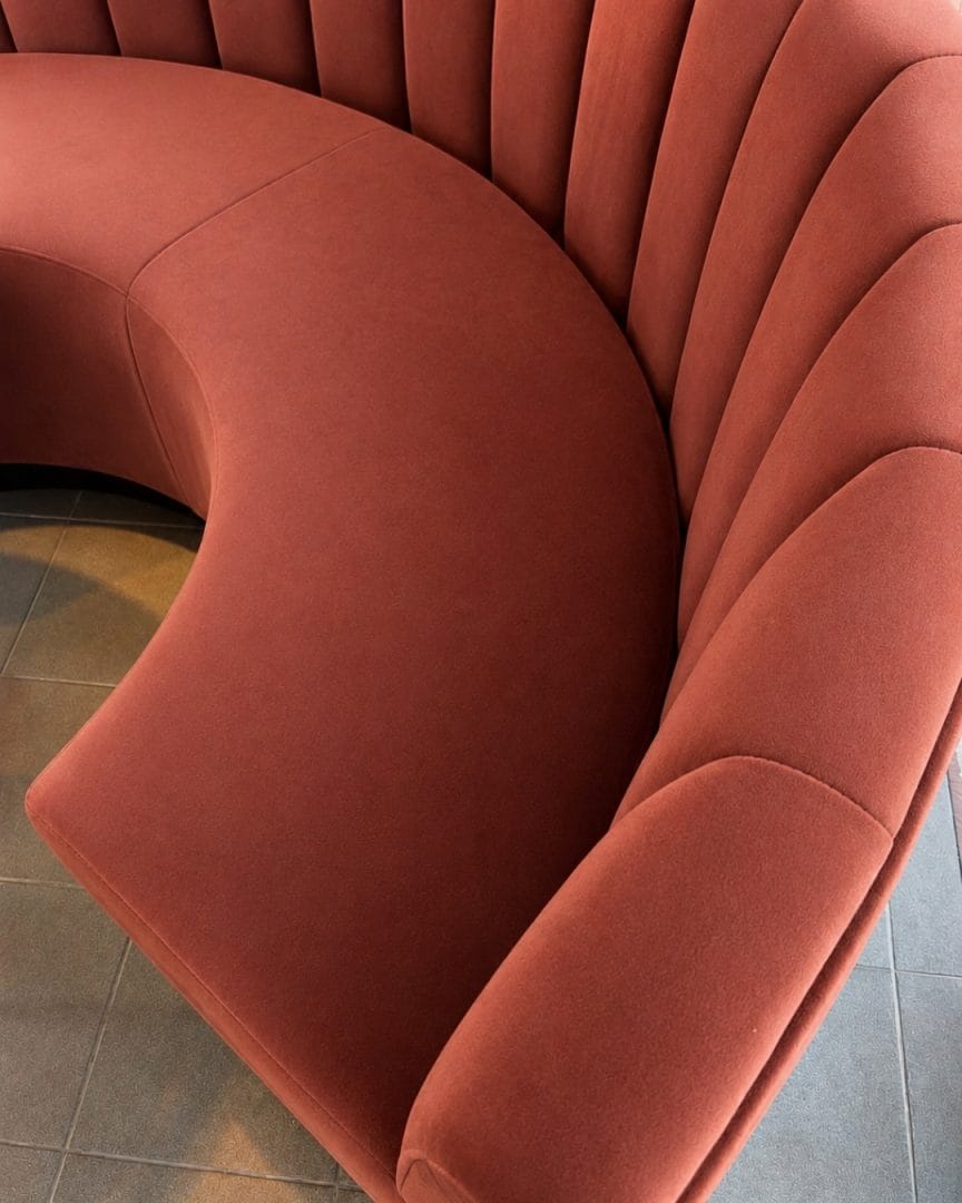 nærbilde av buet sofa til kafe med velur polstring