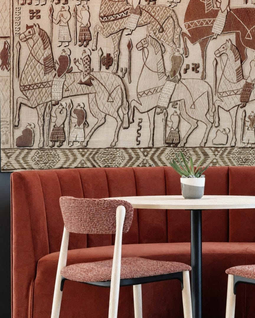nærbildet av rød sofa med kunst på vegg