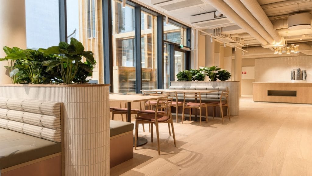 Kantine med lyst interiør og sofaer med buffeøy i bakgrunn