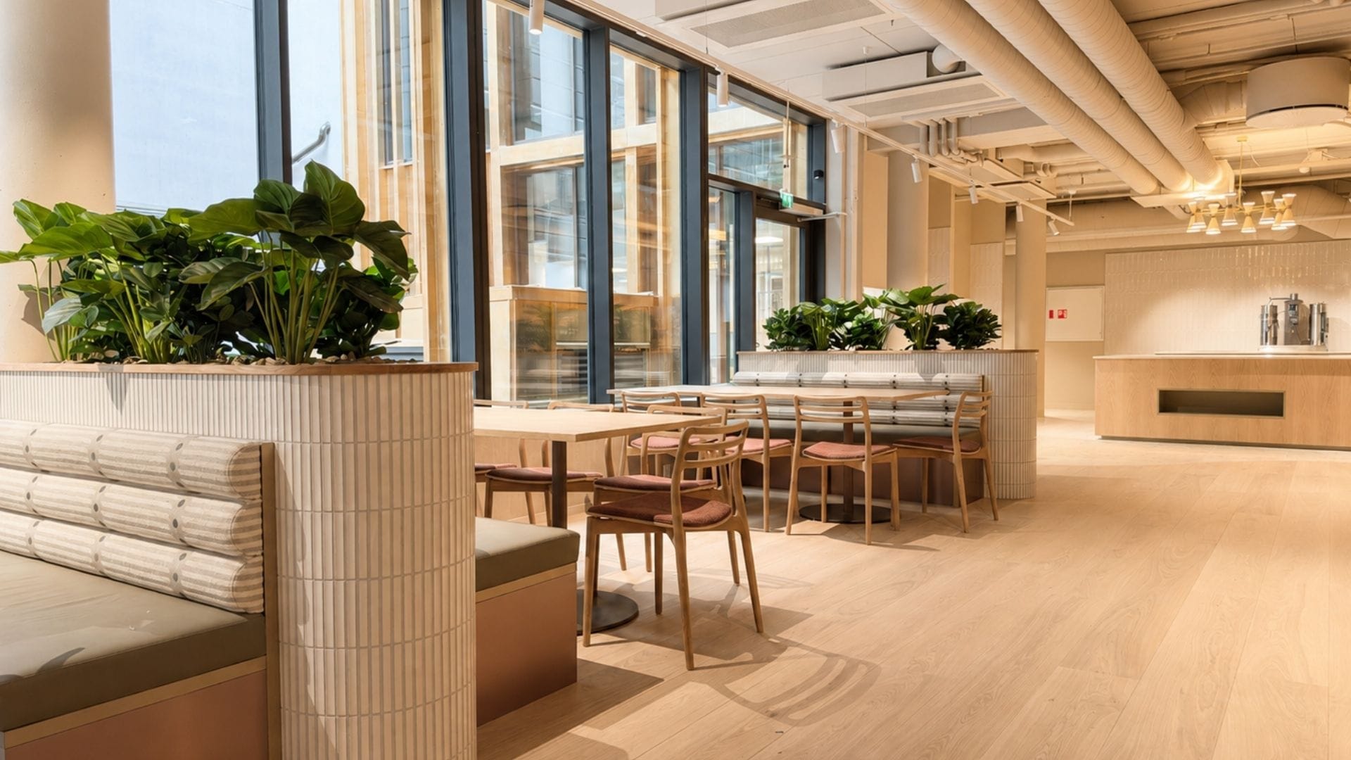 Kantine med lyst interiør og sofaer med buffeøy i bakgrunn
