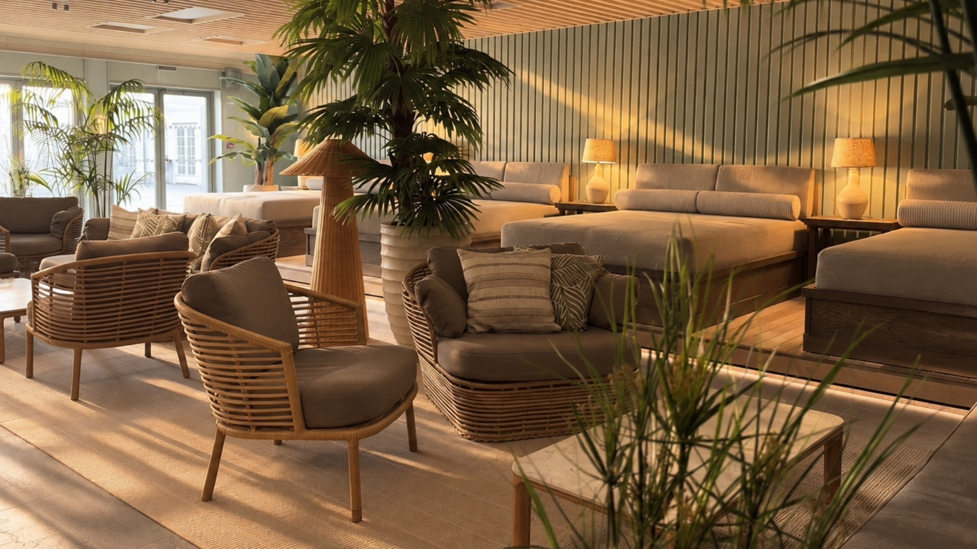 loungeavdeling med stoler sofa og bord og kunstige planter